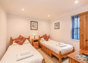 two twin beds in a room with a table at Beachcombers in Newquay Bay Resort