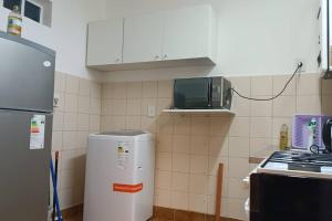 a small kitchen with a refrigerator and a microwave at Insuperable depto en san telmo. in Buenos Aires