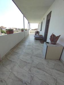 balcón con suelo de baldosa grande y paredes blancas en Guest House Ed&Er en Argavand