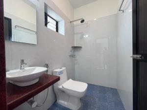 uma casa de banho branca com um WC e um lavatório em Morjim Sunset Guesthouse- Apartments with Kitchen em Morjim
