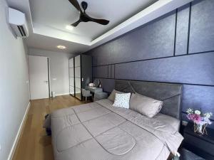 a bedroom with a large bed with a blue wall at Sentral Suites Kuala lumpur By Leyla in Kuala Lumpur