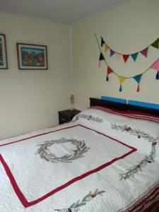 1 dormitorio con 1 cama con manta roja y blanca en Donde la Euli, en Pitrufquén