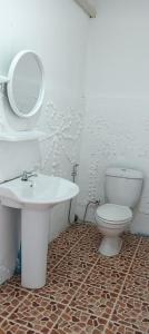 La salle de bains est pourvue de toilettes blanches et d'un lavabo. dans l'établissement Pai sunrise camping resort, à Pai