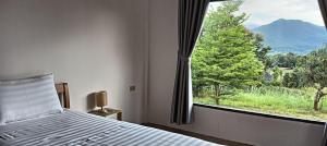 1 dormitorio con cama y ventana grande en Pai sunrise camping resort, en Pai