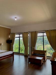 a bedroom with a bed and large windows at Pondok Senaru Cottages in Senaru