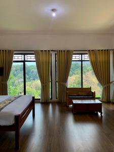 a bedroom with a bed and large windows at Pondok Senaru Cottages in Senaru