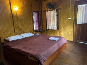 Postel nebo postele na pokoji v ubytování Baan Wisarut Guesthouse