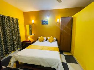 1 dormitorio con 1 cama en una habitación amarilla en Samantha Inn Beach Resort, en Arambol