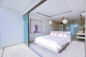 a bedroom with a white bed and glass walls at So Paradise Villa 4 bedrooms in Koh Samui 