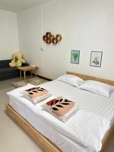 a bedroom with a large white bed with two pillows at Homehana Pua in Pua