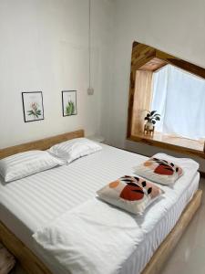 a bedroom with two beds with white sheets and a window at Homehana Pua in Pua