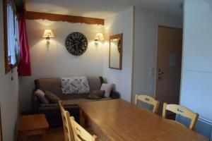 uma sala de estar com uma mesa e um sofá em LES PETITS ETERLOUS Appartement T3 36m2 à Puy St Vincent 1800 Alpes du sud 6 personnes parking privé couvert em Puy-Saint-Vincent