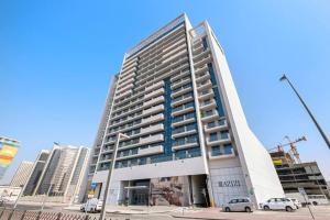 a tall building with cars parked in front of it at Perfect Getaway Studio APT Aura by Aziza in Dubai