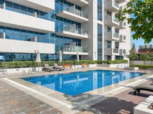 a swimming pool in front of a building at Perfect Getaway Studio APT Aura by Aziza in Dubai