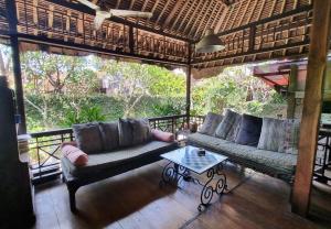 a living room with two couches and a table at Flash Back Bungalow in Sanur