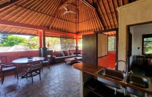a kitchen and living room with a table and a couch at Flash Back Bungalow in Sanur