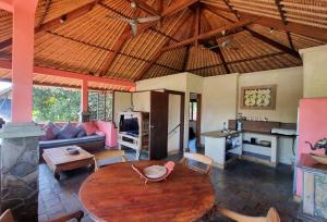 a living room with a table and a kitchen at Flash Back Bungalow in Sanur