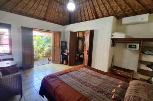 a bedroom with a bed and a desk in it at Flash Back Bungalow in Sanur