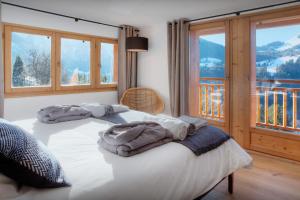 a bedroom with a bed with towels on it at Chalet Manoe - OVO Network in Manigod