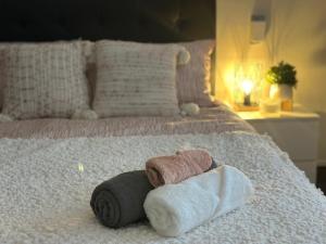 1 cama con 2 toallas y 1 rollo de toallas en Eden Lodge en Auckland