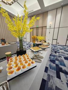 a buffet of food on a long table at Guangzhou Baiyun Airport COCO Hotel T2 Terminal Store Canton Fair Free Shuttle Bus in Huadu