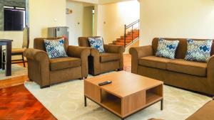 Sala de estar con 3 sofás y mesa de centro en Taliah Homestays, en Nanyuki
