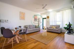 NightcliffNightcliff Nest - Stylish 2BR Apt Near Foreshore的带桌子和沙发的客厅
