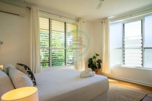 NightcliffNightcliff Nest - Stylish 2BR Apt Near Foreshore的卧室里有一张白色的床和一扇大窗户