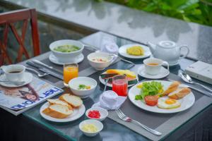 uma mesa coberta com pratos de alimentos e bebidas ao pequeno-almoço em Nam Thu Hotel em Quy Nhon