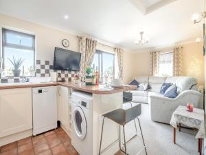 a kitchen and living room with a washer and dryer at Cwtch Corner in New Milton