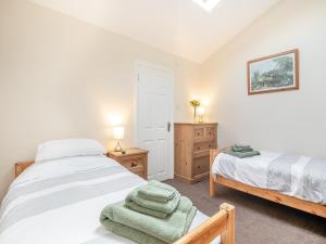 a bedroom with two beds and a nightstand and a bed sidx sidx sidx sidx at Cwtch Corner in New Milton