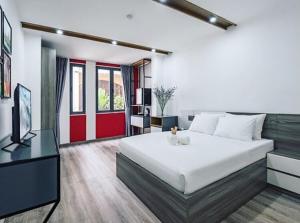 1 dormitorio con 1 cama blanca grande y TV en AILEN BOUTIQUE HOTEL en Ho Chi Minh