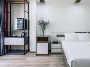 a bedroom with a bed and a desk with a microwave at AILEN BOUTIQUE HOTEL in Ho Chi Minh City