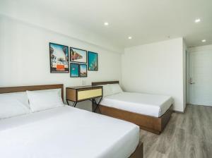 a hotel room with two beds and a desk at AILEN BOUTIQUE HOTEL in Ho Chi Minh City