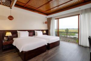 Giường trong phòng chung tại Athena Premier Resort Ninh Bình