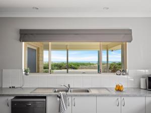 a kitchen with a sink and a large mirror at The Dunes Pet Friendly Beachfront Family Retreat Busselton in Busselton