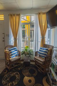 sala de estar con 2 sillas y ventana en Mahale - Quepos Manuel Antonio Reserve, en Quepos