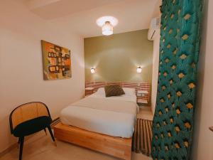 um pequeno quarto com uma cama e uma cadeira em Ramla Valley Vista in Nadur Gozo em Nadur