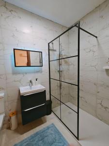 y baño con lavabo y ducha acristalada. en Ramla Valley Vista in Nadur Gozo, en Nadur