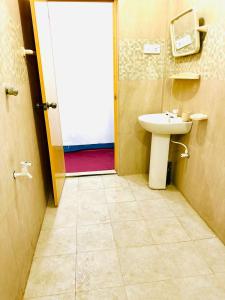 a bathroom with a toilet and a sink and a door at TPK Trinco Holiday Inn in Trincomalee