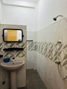 a bathroom with a sink and a shower with a mirror at TPK Trinco Holiday Inn in Trincomalee
