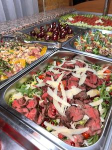 un buffet avec de nombreux plateaux de différents types de nourriture dans l'établissement Hotel Dobru, à Slănic-Moldova