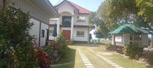 a white house with a gate and a yard at Seven Waves Beachfront Residence 