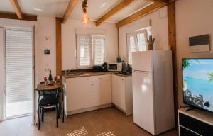eine Küche mit einem Kühlschrank, einem Tisch und einem TV in der Unterkunft Marina Oceano in La Mareta