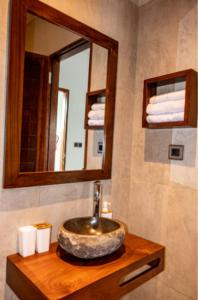 a bathroom with a stone sink and a mirror at Santai Toraja in Rantepao