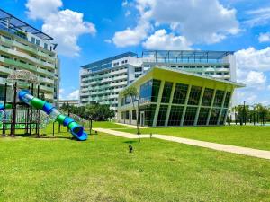 a large building with a slide in front of a park at Relaxing and Cozy Unit at The Residences in Manila