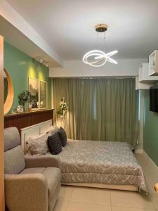 a bedroom with a bed and a couch at Relaxing and Cozy Unit at The Residences in Manila