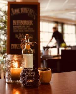 a candle and a glass bottle on a table at Grong Hotell in Grong