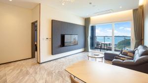 Una sala de estar con un sofá y un televisor. en Ganghwa Elijah Resort, en Incheon