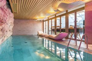 a pool with lounge chairs in a hotel room at Hôtel B55 in Paris